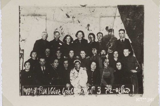 Kuchnia ludowa, marzec 1941 r. Zdjęcie grupowe pracowników. W pierwszym rzędzie od dołu druga kobieta od prawej - Regina Rumkowska, żona Chaima Rumkowskiego. Zbiory ŻIH